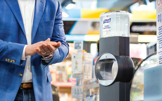 Sanitizer Stands A man is sanitizing his hands at a Sanitizing station