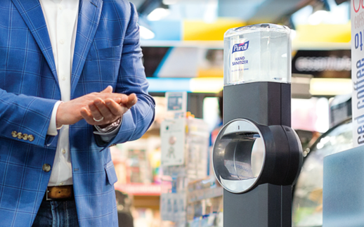 A man is sanitizing his hands at a Sanitizing station